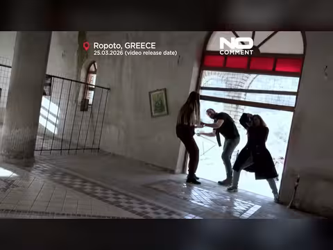 سياح يتجربون الكنيسة المائلة في قرية روبوتو اليونانية