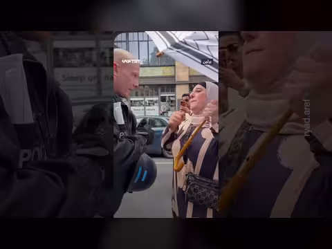 شرطي ألماني يمنع سيدة من حمل مظلة فلسطينية