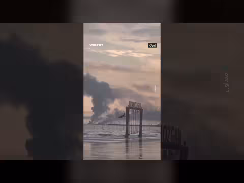 طفلة تلهو على أرجوحة وسط دخان القصف