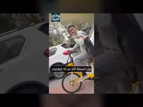 رجل يستعرض سمكة كبيرة في بكين