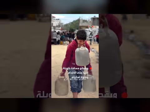 طفل في غزة يحمل جالونات مياه بأسنانه