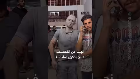 شاب فلسطيني يسير بعد نجاته من قصف إسرائيلي في غزة