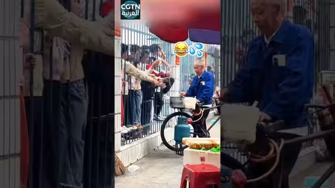 رجل مسن يوزع غزل البنات مجاناً على تلاميذ مدرسة في الصين