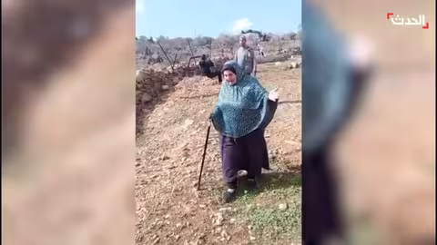 فلسطينية تبكي تجريف أراضيها واقتلاع زيتونها في قريوت