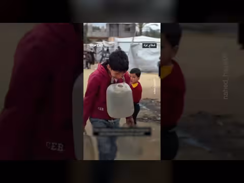 طفل فلسطيني يحمل غالونات الماء بأسنانه