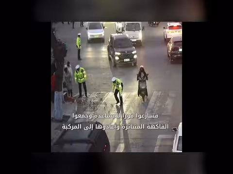 رجال الشرطة والمارة يساعدون في جمع الفاكهة المتناثرة