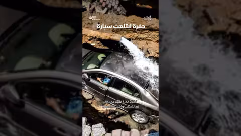 سيارة تبتلعها حفرة في الطريق