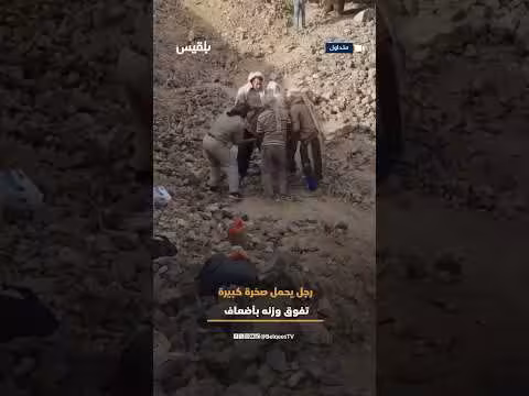 رجل يحمل صخرة كبيرة تفوق وزنه