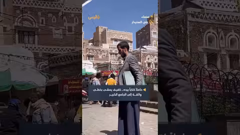 شاب كفيف يعبر إلى الجامع الكبير بصنعاء ومعه كتابه